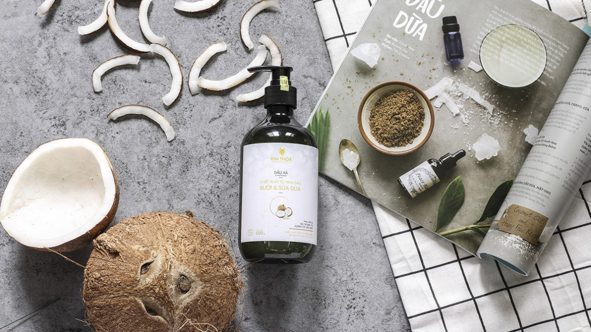 Coconut oil bottle and coconut placed on the table