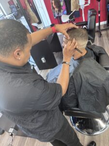 Barber giving a haircut in salon chair.