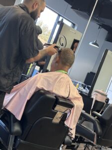 Man getting haircut in a barbershop chair.