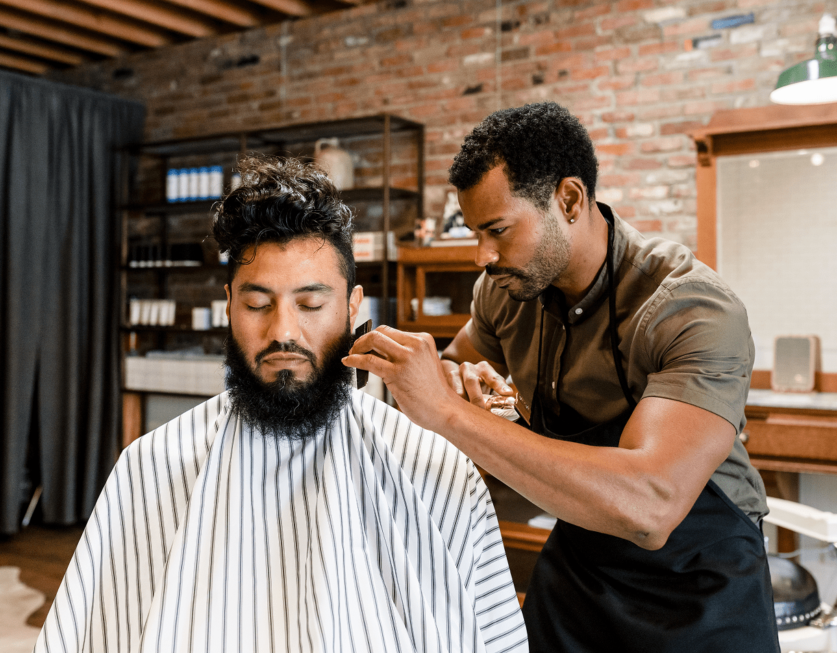 Professional barber grooming a customer's beard