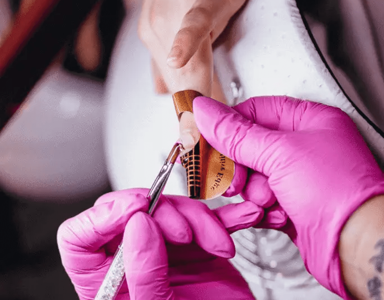 Nail technician shaping acrylic extension