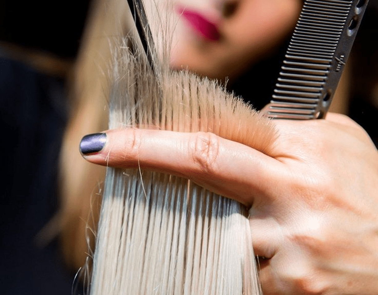 Stylist using scissors and comb on hair